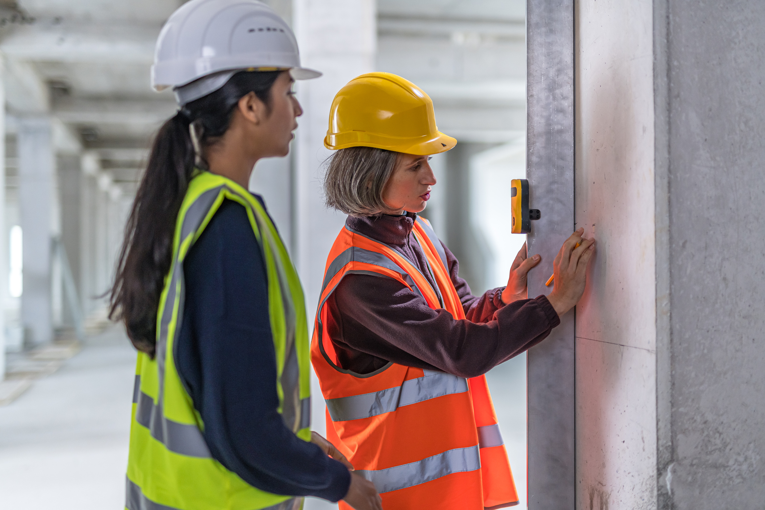 Construction workers measuring support beam